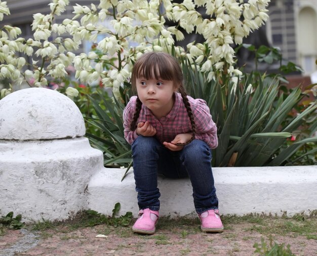 Beautiful young girl siting on flowers background