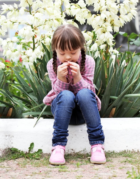 Beautiful young girl siting on flowers background.