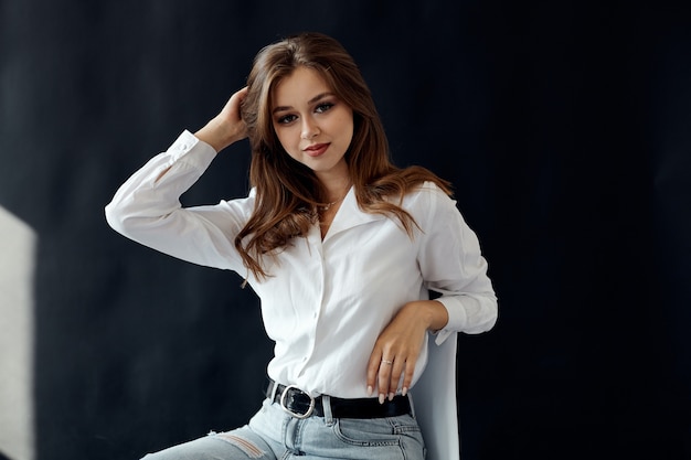 Photo beautiful young girl sitting on a chair