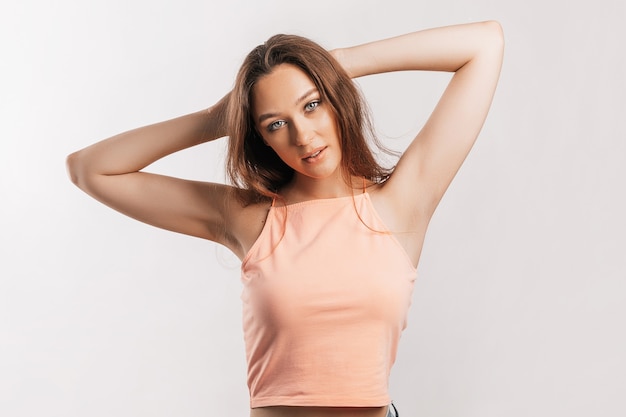 Beautiful young girl smiling and posing looking at the camera on a white isolated background. Positive brunette woman. Kind look. Beauty face.