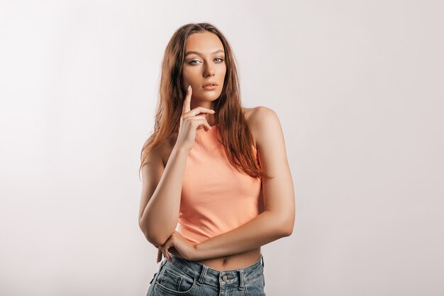 Beautiful young girl smiling and posing looking at the camera on a white isolated background. Positive brunette woman. Kind look. Beauty face.