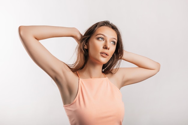 Beautiful young girl smiling and posing looking at the camera on a white isolated background Positive brunette woman Kind look Beauty face