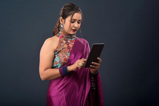 Beautiful young girl using mobile phone or smartphone on gray background