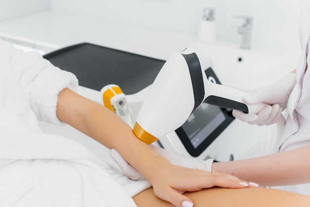 A beautiful young girl will undergo laser hair removal with modern equipment in a Spa salon. Beauty salon. Body care.