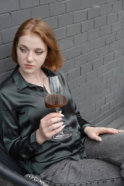 Beautiful young girl with coffee in a glass on the terrace