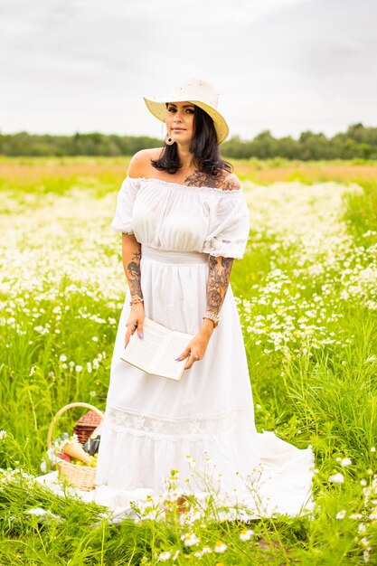 Beautiful young girl with curly red hair in camomile field