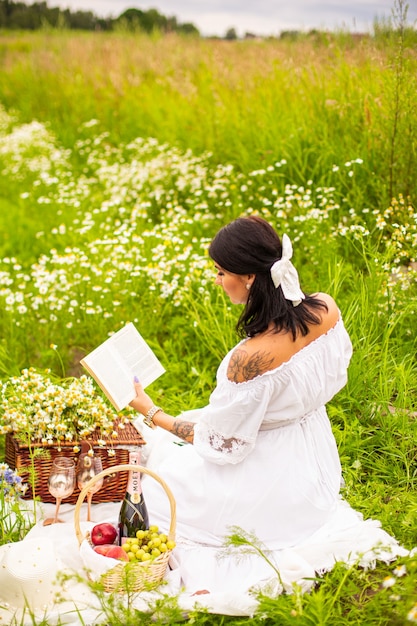 Beautiful young girl with curly red hair in camomile field