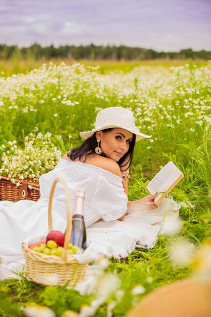 camomile 필드에 곱슬 빨간 머리를 가진 아름 다운 젊은 여자