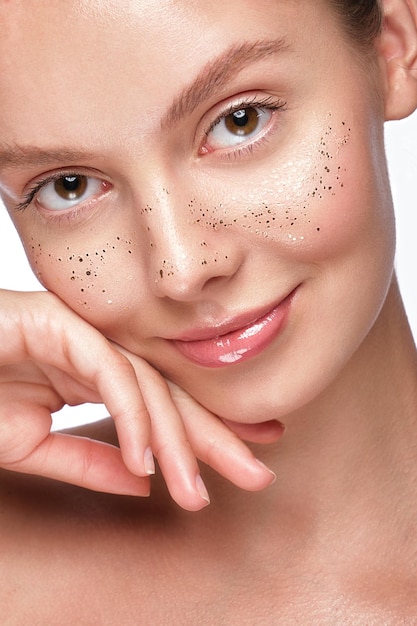 Beautiful young girl with a light natural makeup glitter freckles and perfect skin Beauty face