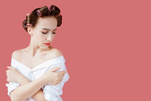 Bella ragazza con una maschera e bigodini toccando il suo viso.