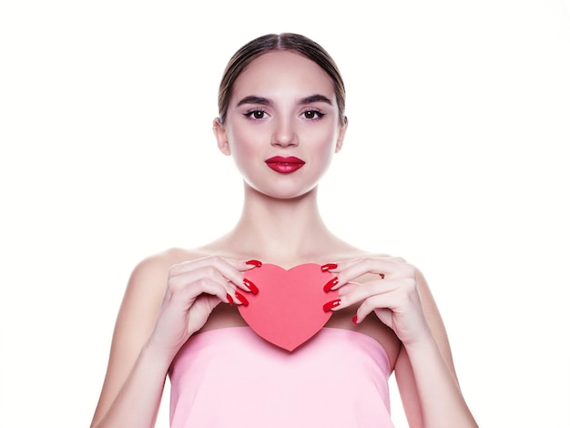 Photo beautiful, young girl with a paper heart in her hands. love concept. beautiful smiling young woman. gift for valentine's day. isolated on white background.