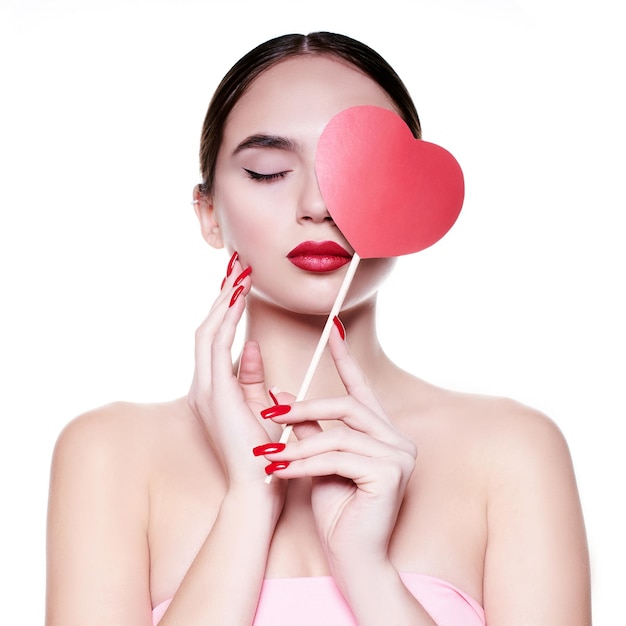 Beautiful, young girl with a paper heart in her hands. Love concept. beautiful smiling young woman. Gift for Valentine's Day. Isolated on white background.