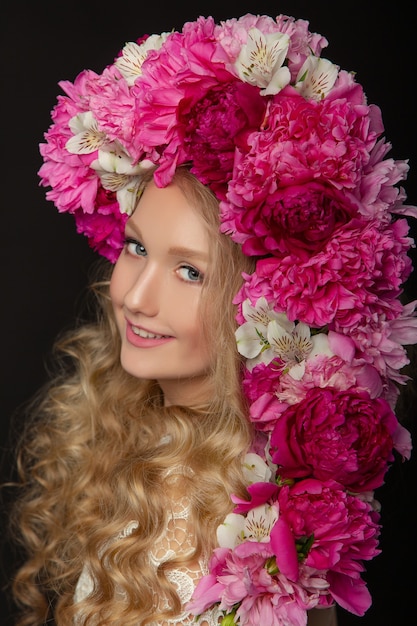 Beautiful young girl with peonies