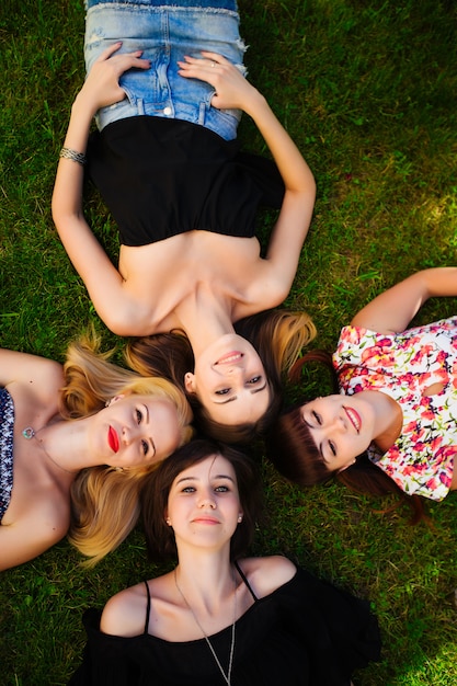 Beautiful young girls lying on the grass