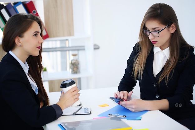 Photo beautiful young girls in the office business style