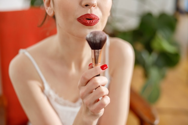 Beautiful young happy caucasian woman at cozy home with cosmetics at sunny morning