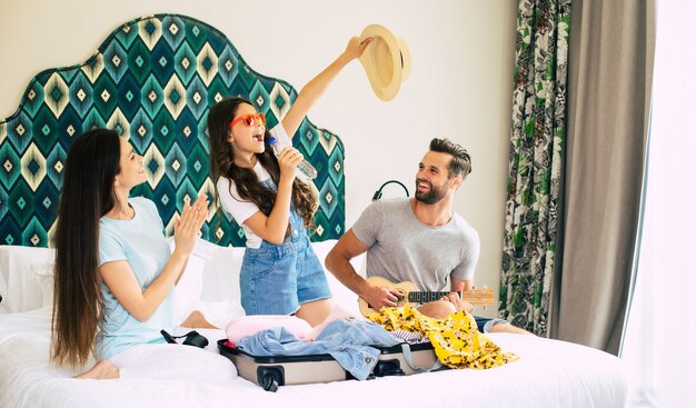 Beautiful young happy and excited family in a luxury hotel room while unpacking