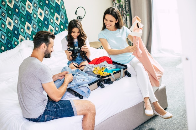 Beautiful young happy and excited family in a luxury hotel room while unpacking