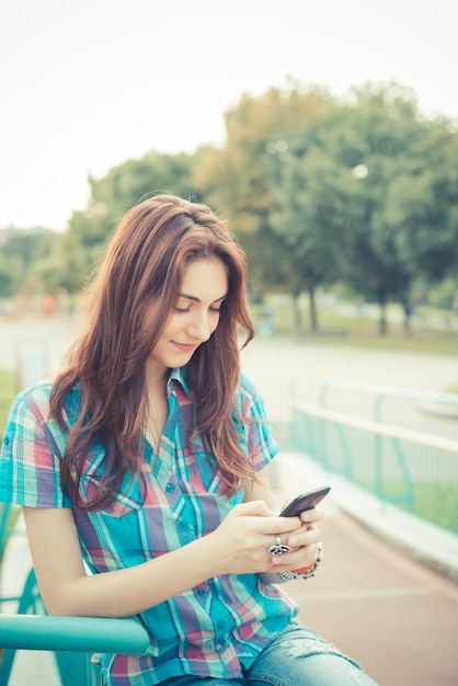 beautiful young hipster woman using smartphone