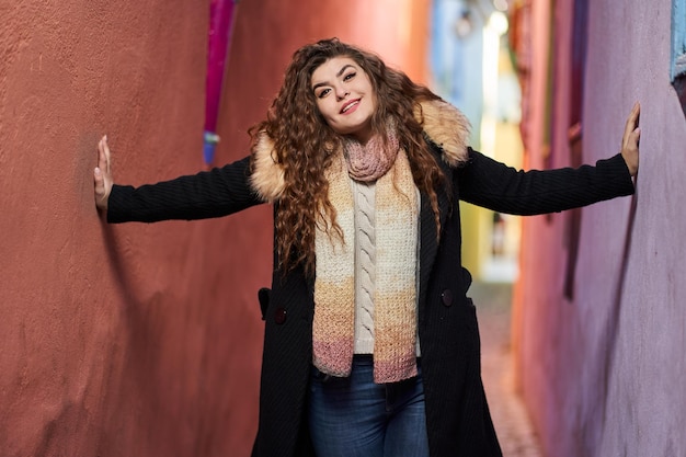 A beautiful young hispanic woman on a narrow street in an old\
town