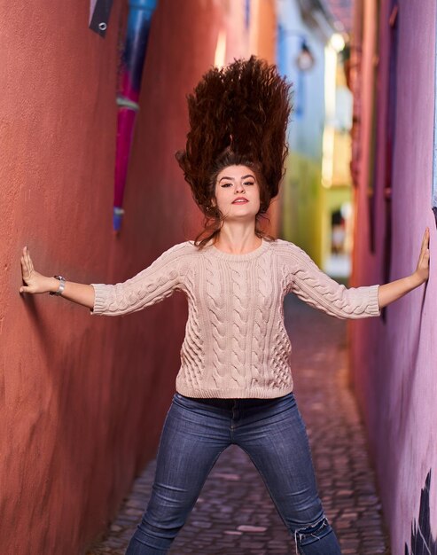 A beautiful young hispanic woman on a narrow street in an old\
town