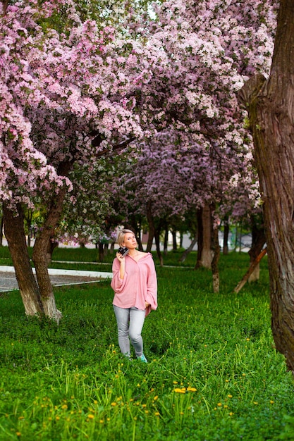 Beautiful young lady in the garden of cherry blossoms