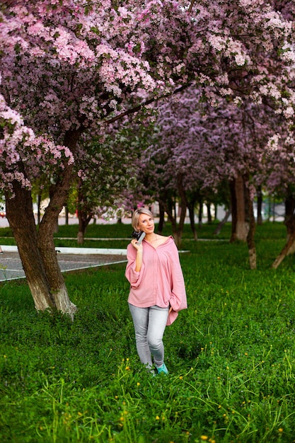 Beautiful young lady in the garden of cherry blossoms