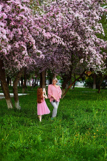 Beautiful young lady in the garden of cherry blossoms