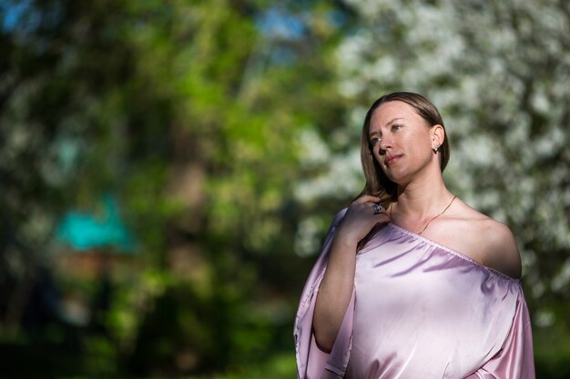 Beautiful young lady in the garden of cherry blossoms