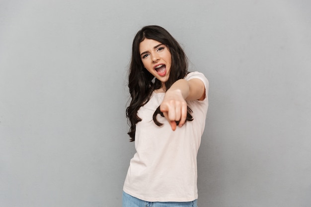 Beautiful young lady pointing to you.