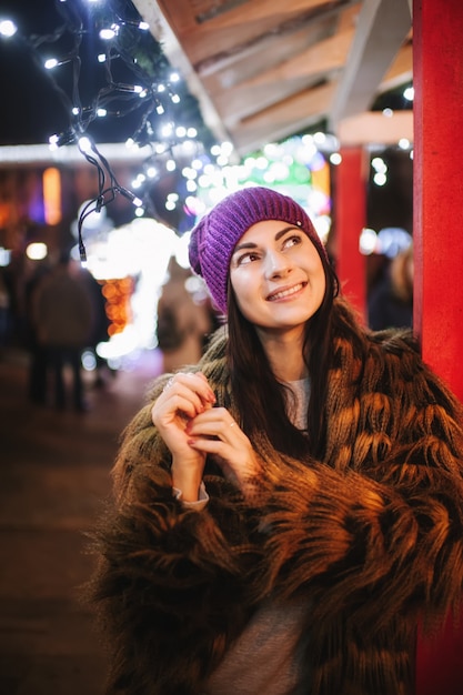 The beautiful young lady standing near Christmas fair