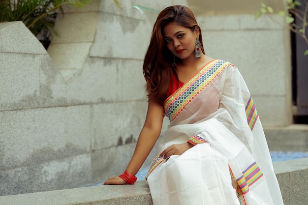 Beautiful young lady wearing saree with sleeveless blouse, white saree, red blouse, color hair