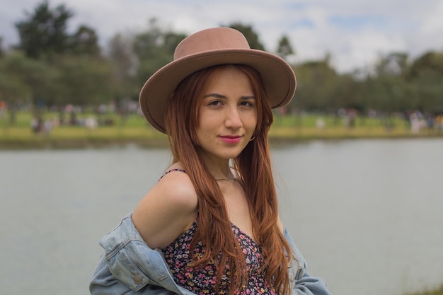 beautiful young latina relaxing on a sunny day next to a lake in simon bolivar park in bogota