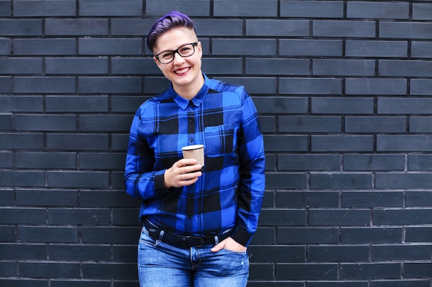 Beautiful young lesbian woman near a brick wall