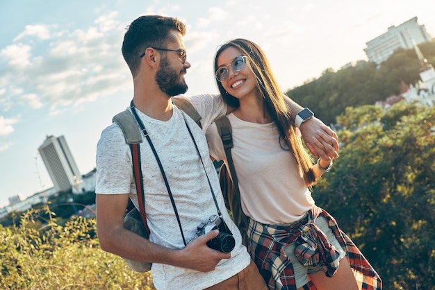 屋外で時間を過ごしながら抱きしめて笑っている美しい若い愛情のあるカップル