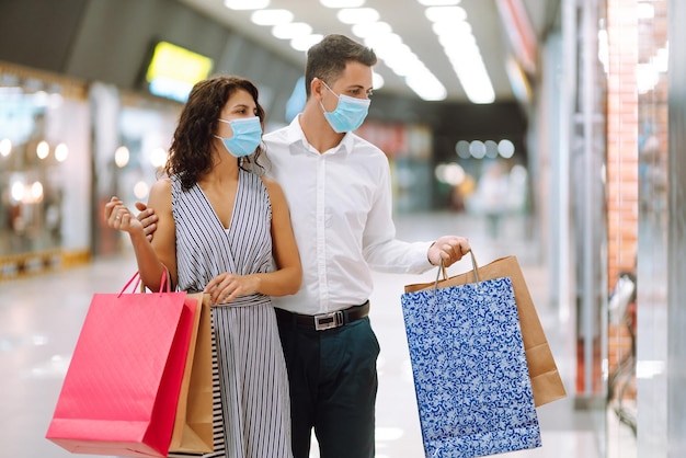 Beautiful young loving couple shopping together black friday\
concept