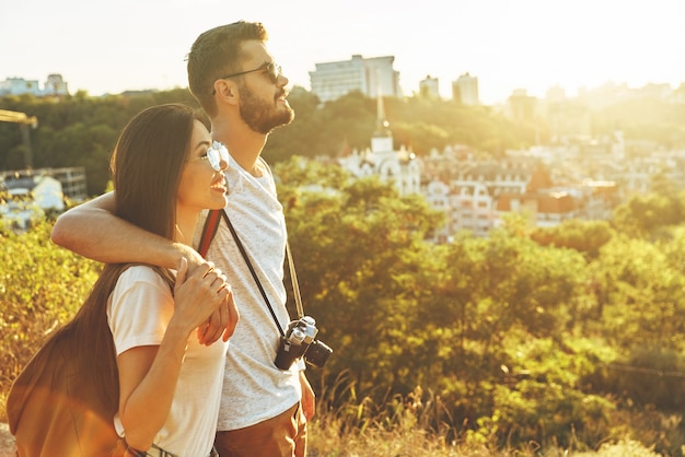 屋外の景色を楽しみながら笑顔と抱きしめる美しい若い愛情のあるカップル