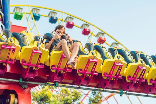 写真 遊園地で楽しんでいる美しい、若い男。