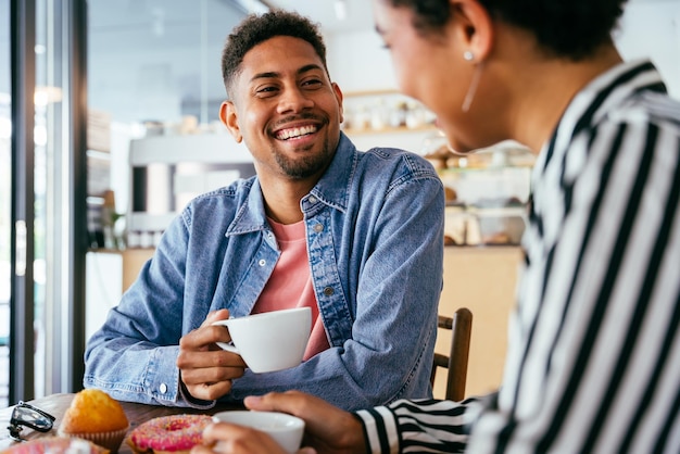 Beautiful young mixed race couple bonding and sitting in a bar cafeteria