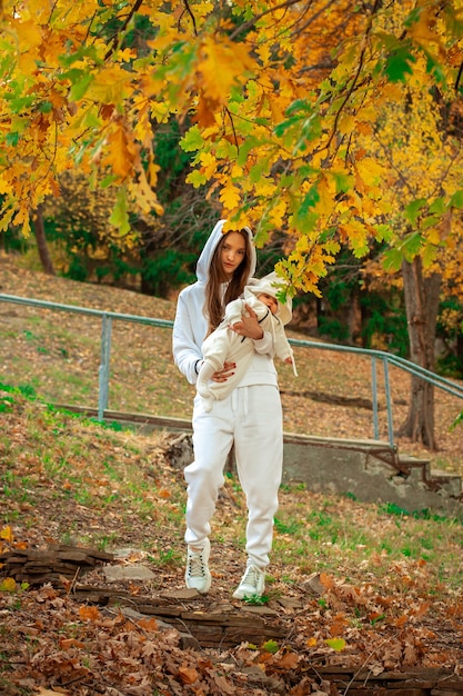 Beautiful young mom with baby girl in autumn