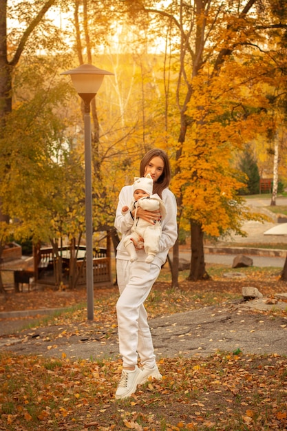 Beautiful young mom with baby girl in autumn