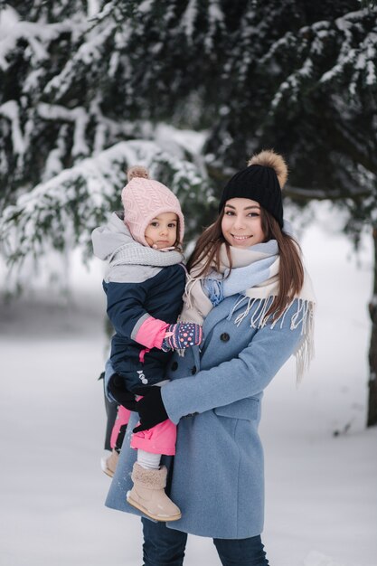 겨울 공원에서 귀여운 딸과 함께 아름 다운 젊은 엄마