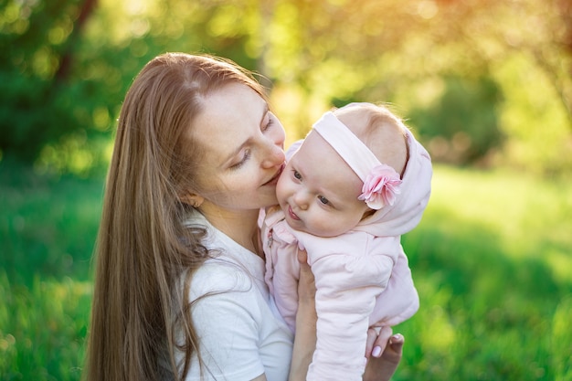 Beautiful young mother hugging baby daughter. Tenderness and care