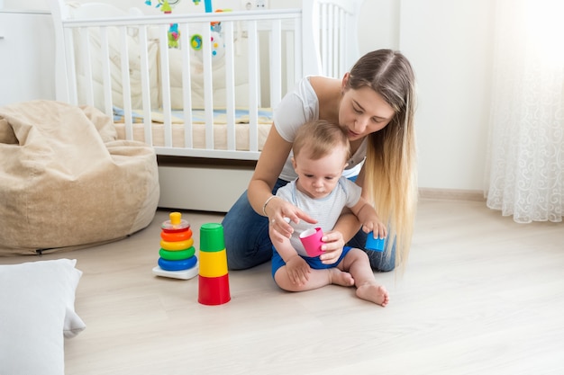 美しい若い母親は彼女の幼児の世話をしています