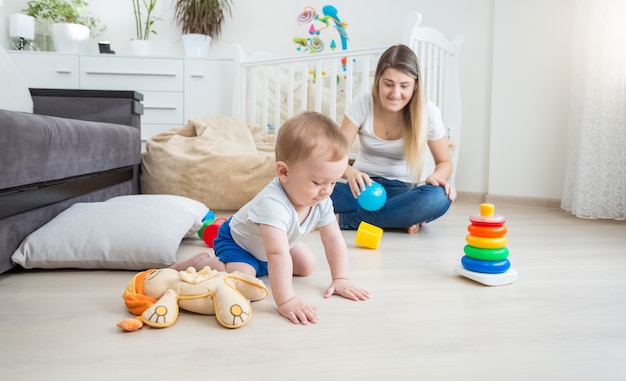 美しい若い母親は彼女の幼児の世話をしています