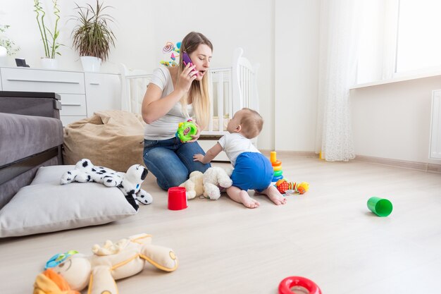 美しい若い母親は彼女の幼児の世話をしています