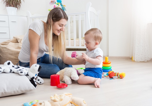 美しい若い母親は彼女の幼児の世話をしています