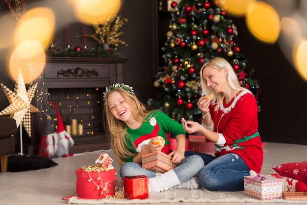 Beautiful young mother with her daughter near the Christmas tree