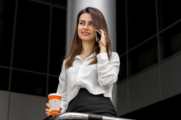 beautiful young Office Lady in white shirt smiling and talking on the phone