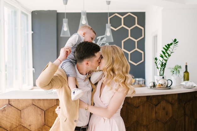 Photo beautiful young parents smile with their one-year-old child at home